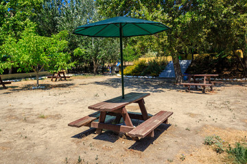 Resting place in the park with bench table and sun umbrellas