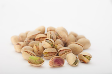 Heap of dry salted pistachio fruit on white background