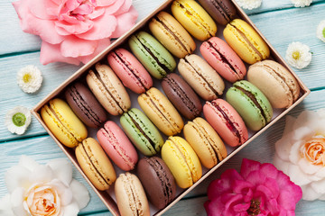 Colorful macaroons in a gift box and roses