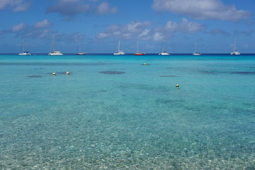 Seascape of a tropical lagoon with turquoise water and boats anchored, south Pacific ocean, atoll of Rangiroa, Tuamotu archipelago, French Polynesia
