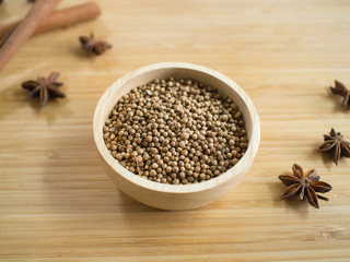 Coriander seeds in wooden bowl  and on twooden board.
