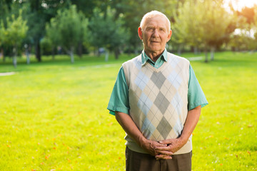 Senior man standing outdoors. Older male on nature background. I recall faces and names. Thoughts and guesses.