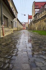 Fototapeta na wymiar Potaissa Street with remains of medieval walls in the Old City of Cluj, Romania