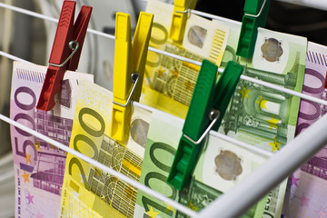 Geldwäsche/ Korruption/ Steuerhinterziehung: Euroscheine in der Waschmaschine/ am Wäscheständer
