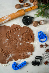 Fototapeta na wymiar Making traditional christmas gingerbread cookies. Christmas-tree branches, a rolling pin, whisk for whipping eggs, nuts and cones they lie on a table nearby