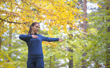 Obraz premium Energetic young woman do exercises outdoors in park to keep their bodies in shape. Fitness concept. Body-building theme. Sport mood.