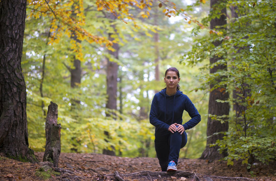 Energetic young woman do exercises outdoors in park to keep their bodies in shape. Fitness concept. Body-building theme. Sport mood.