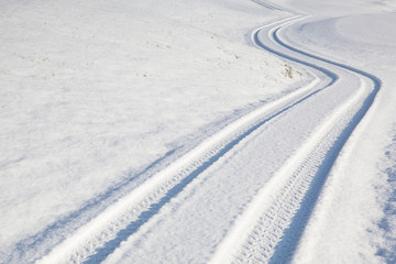 Car tire track on winter road