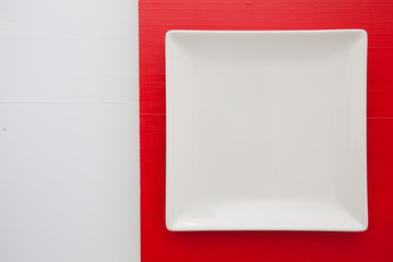 Empty white ceramic dish on over red and white background