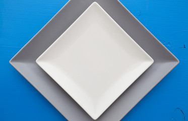 Empty white ceramic dish on over blue wooden table
