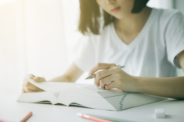 female hands with pen writing on book