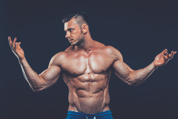 strong athletic man on black background