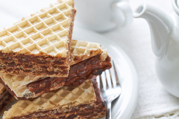 Stack of wafer sheets filled with caramelized sugar and hazelnut cream served on white plate