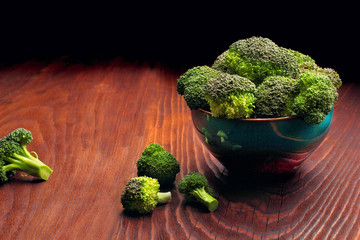 Healthy Green Organic Raw Broccoli in colour plate Ready for Cooking.dark woooden table