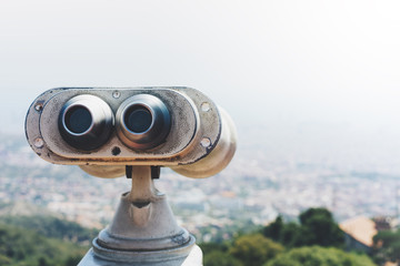 Touristic telescope look at the city with view of Barcelona Spain, close up old metal binoculars on background viewpoint overlooking the mountain, hipster coin operated in panorama observation, mockup