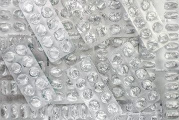 blank capsule of antibiotics in blister packaging close up on a light background, texture