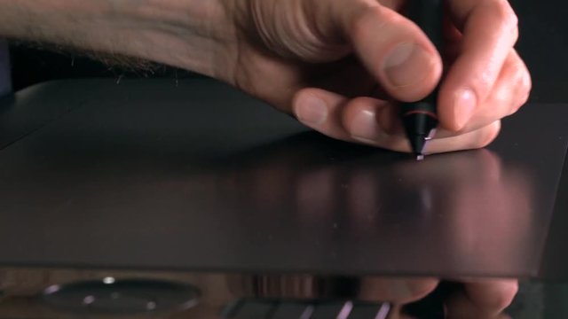 Left-handed artist working with drawing tablet for PC. 4K close up shot