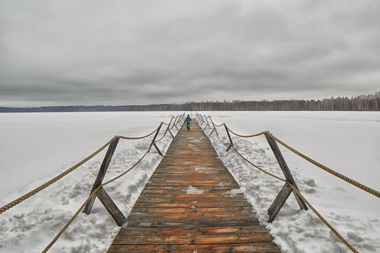 Wooden pier on a frozen winter lake