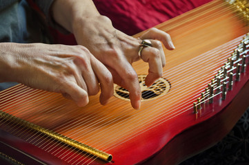 Playing music on lap harp in closeup view/Close-up of playing lap harp made out of redwood with...