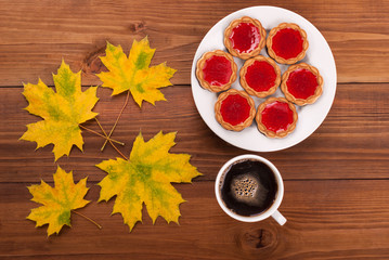 Coffee and cookies autumn leaves on a wooden table.
