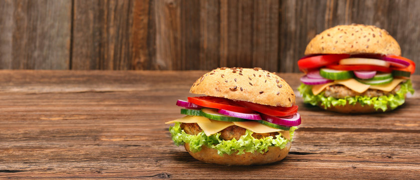 Fresh tasty burger on wooden table and space for text