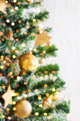 Christmas golden ornaments on blured tree closeup