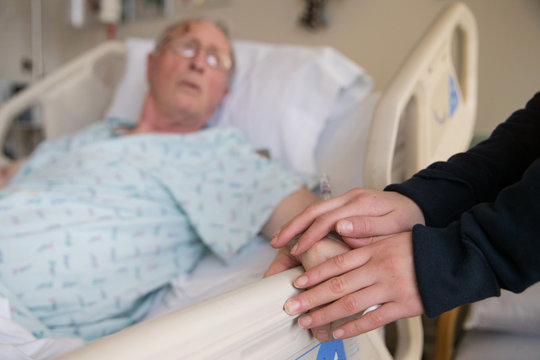 holding hands with elderly patient at hospital