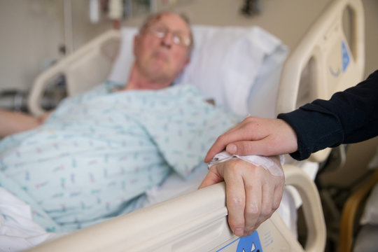 holding hands with elderly patient at hospital
