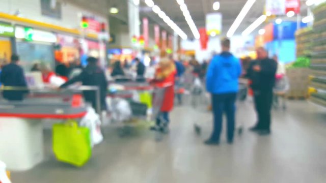People at the checkout in a supermarket, blurred background
