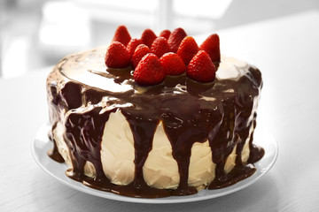 Cake with caramel and strawberries on table