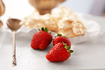 Strawberries and spoon on wooden table
