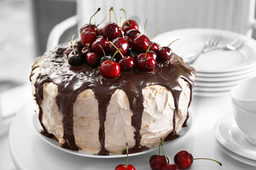 Cake with caramel and cherries on table