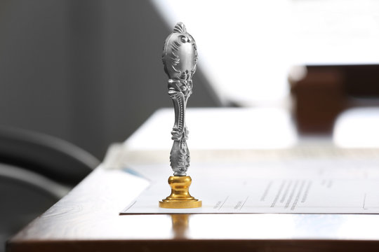 Metal Stamp And Document On Notary Public Table