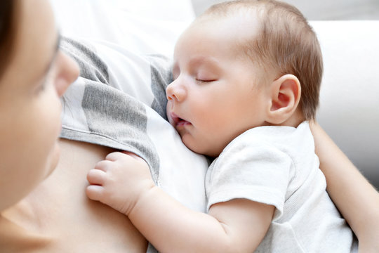 Woman Holding Cute Sleeping Baby, Close Up View