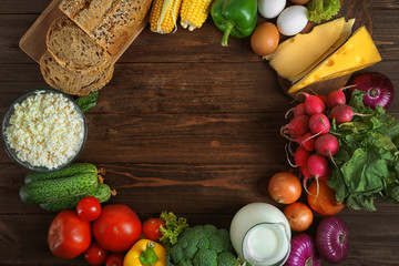 Frame with vegetables and dairy products on wooden background, top view