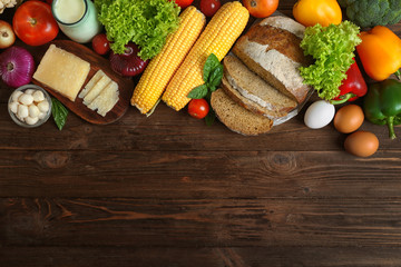 Vegetables and dairy products on wooden background, top view