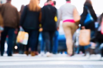 out of focus picture of people crossing a street