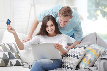 Happy couple with laptop shopping online