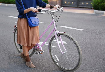 Young woman with bicycle on road
