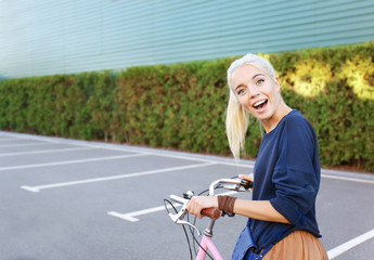 Pretty young woman with bicycle outdoors