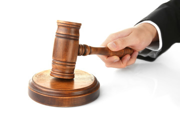 Judge's hand holding gavel on white background