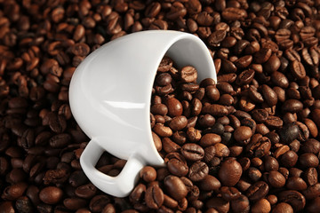White cup and coffee beans, close up view