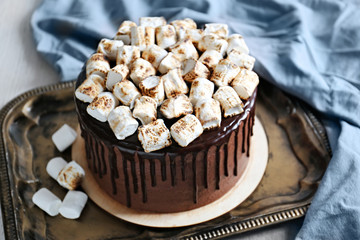 Tasty chocolate cake with marshmallow on tray