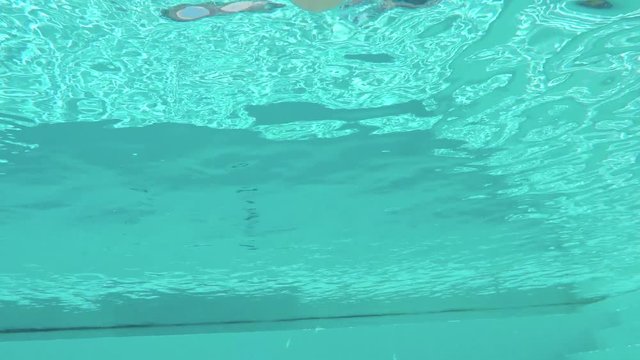 FPV UNDERWATER: Adventures woman submerging in water and diving in swimming pool
