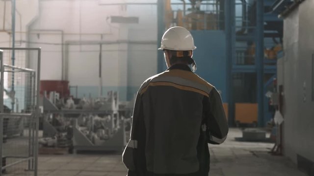 worker wearing safety hat and uniform in a modern factory