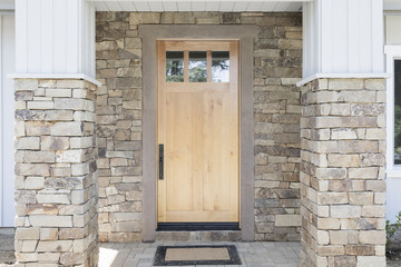 Wood front door of a home. View of a rustic front door in modern