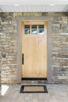 Wood front door of a new home. View of a rustic front door in modern