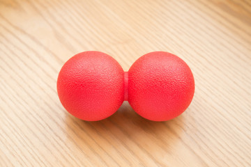 red small massage ball on a wood table