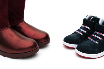black shoes for son and red ones for mom on white as filiation concept