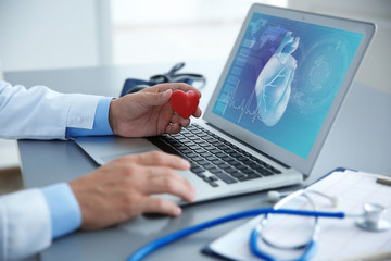 Cardiologist working with laptop at office. Health care concept.